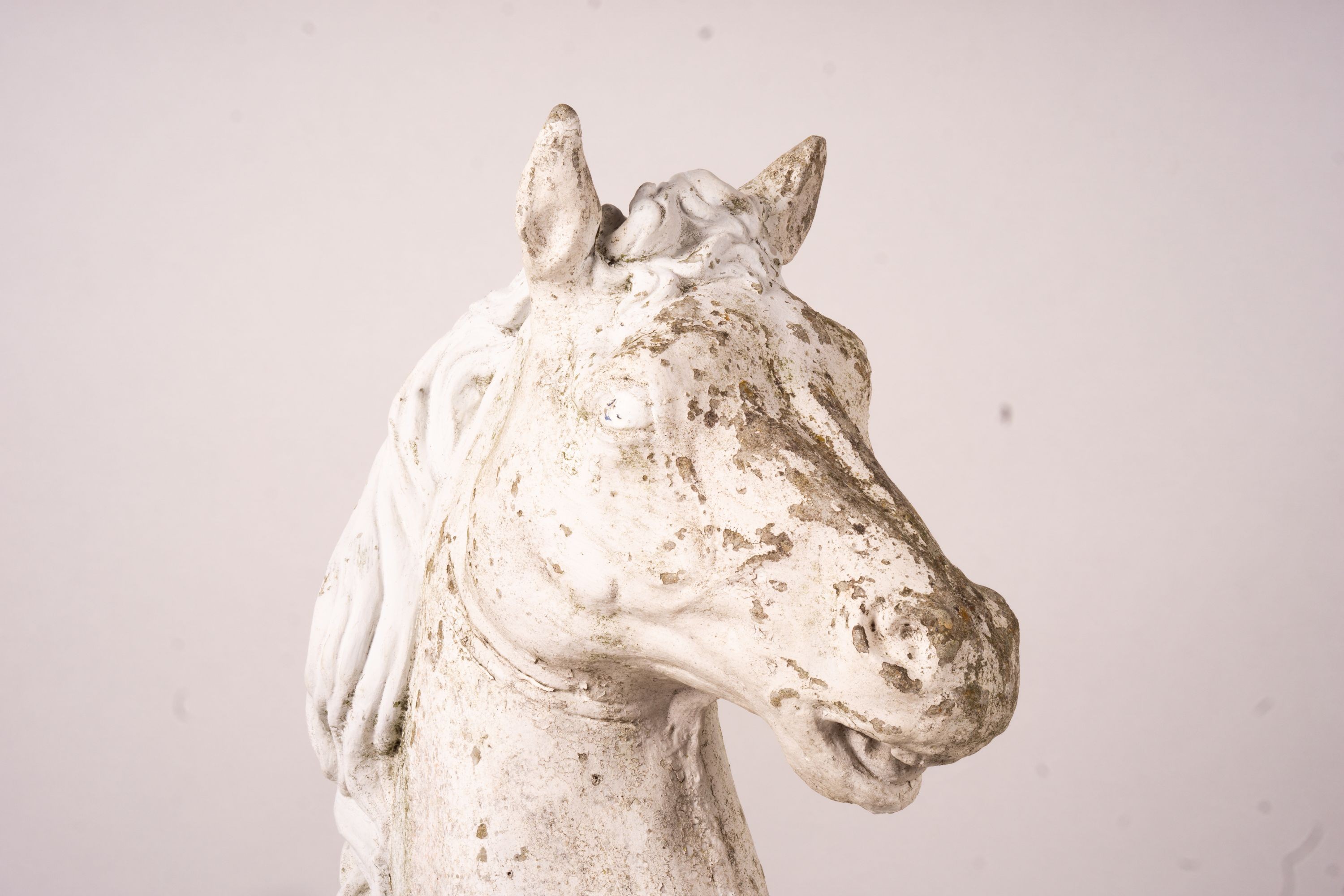 A pair of reconstituted stone horse's heads on plinth bases in the style of Austin and Seeley, height 104cm